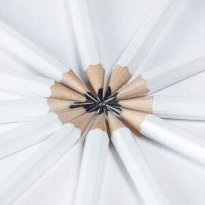 Top view of white pencils arranged in a radial pattern on a white background, emphasizing harmony and creativity.